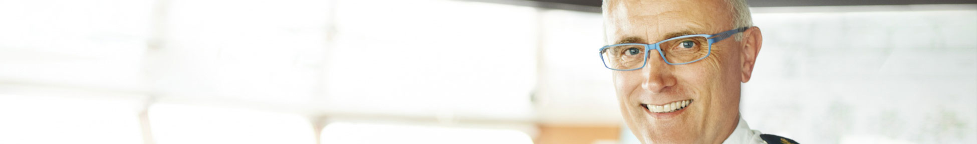 Smiling senior deck officer on the bridge of a ship