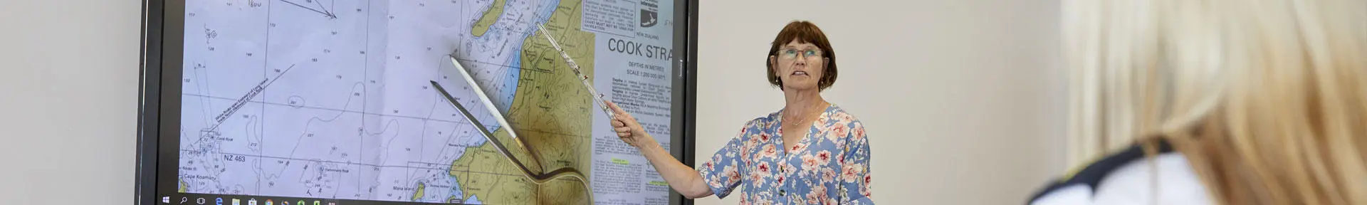 Deck lecturer pointing to a chart on the screen in the classroom
