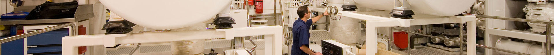 A superyacht engineer inspecting the machinery in the engine room