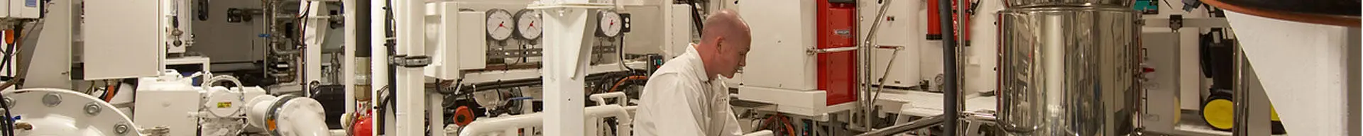 A superyacht engineer inspecting machinery in the engine room