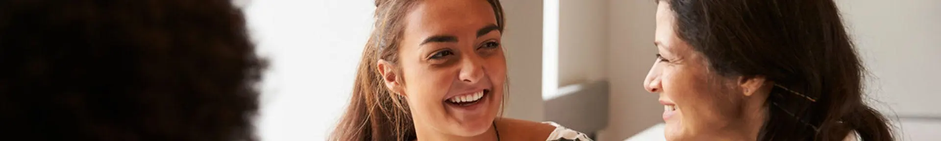 A student and a lecturer smiling at each other while working