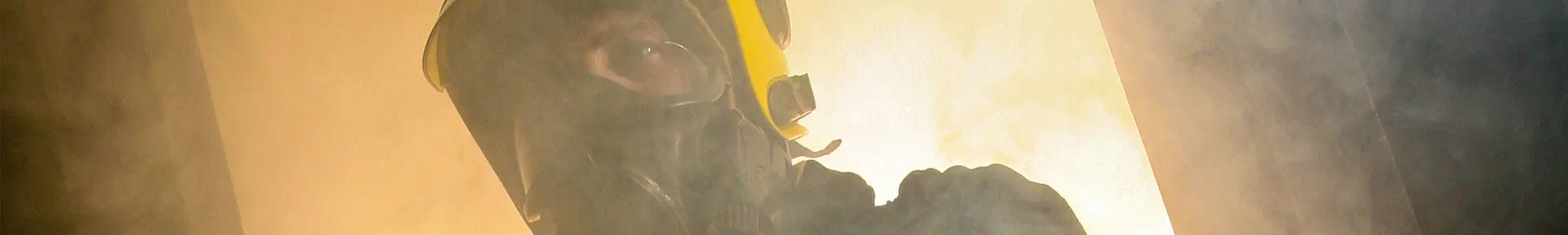Close-up of a fire fighting student in a burning building