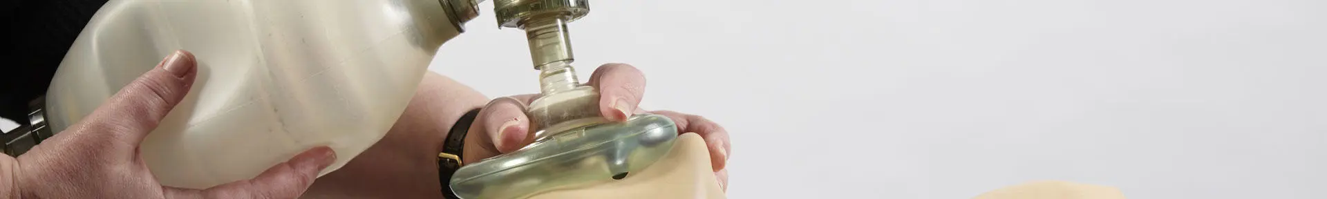 A student using an oxygen mask on a medical dummy