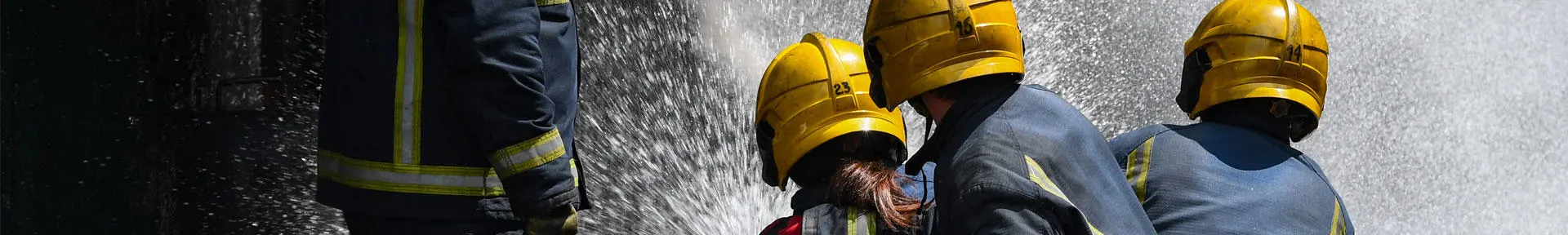 Three fire fighting students using a fire hose
