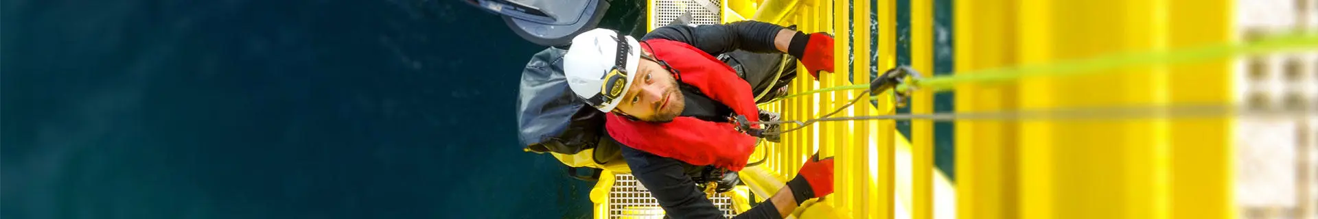 A person climbing a ship's pilot ladder from a pilot boat.