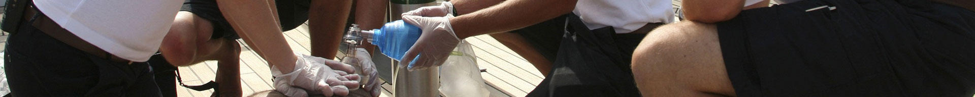People giving a person CPR on the deck of a superyacht