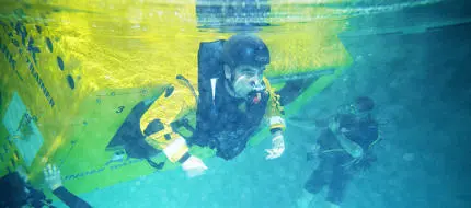 A student escaping from a capsized vessel underwater