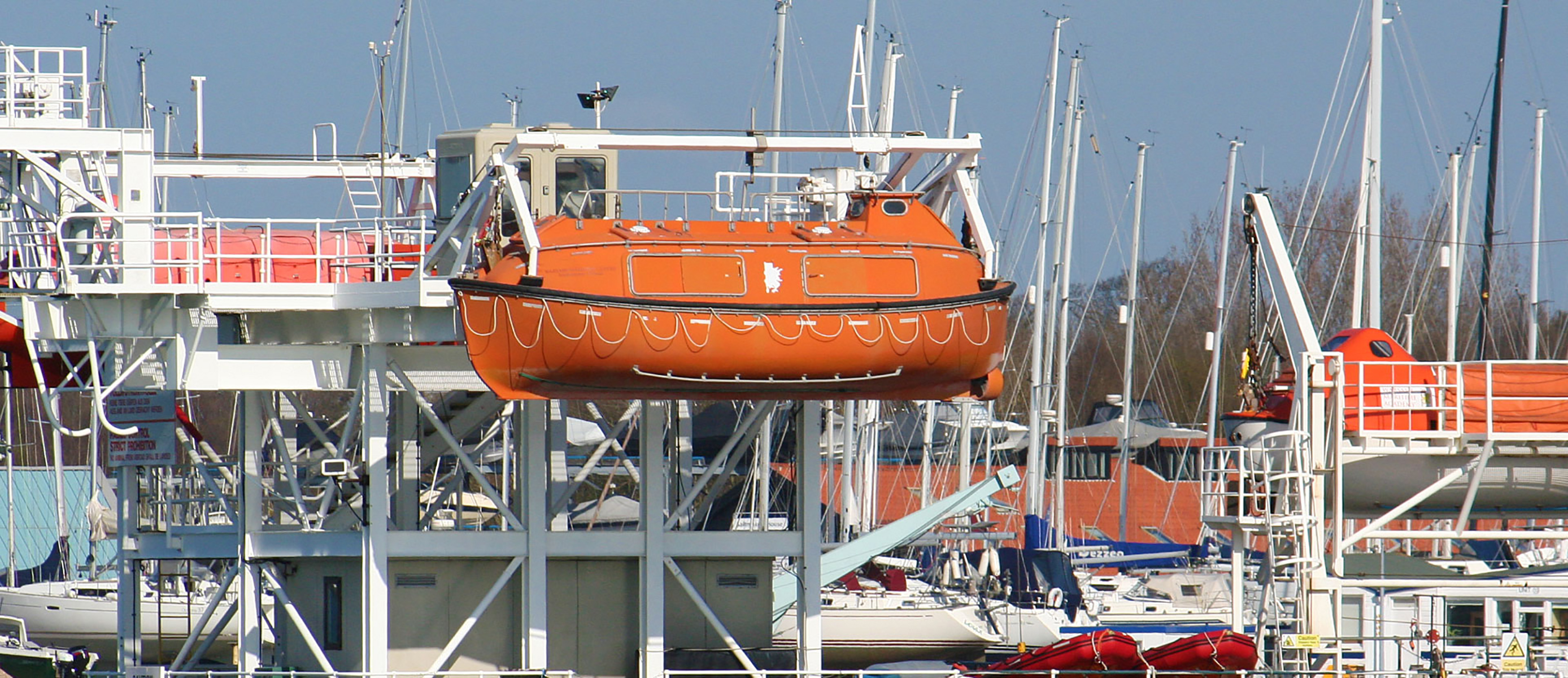 Lifeboat suspended at the end of the pier by the Hamble River