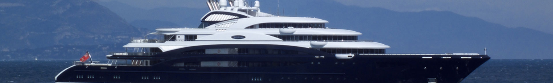 A superyacht with a dark blue hull at anchor