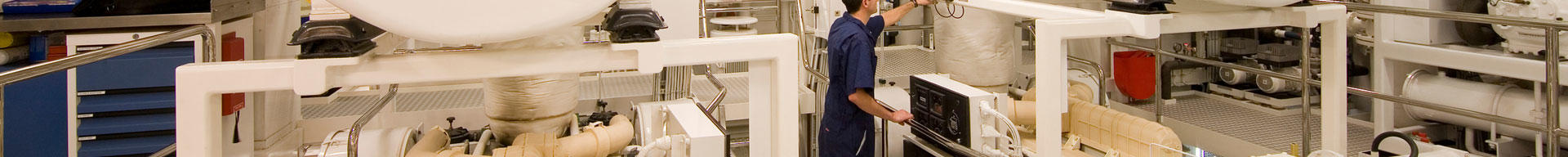 A superyacht engineer inspecting the machinery in the engine room