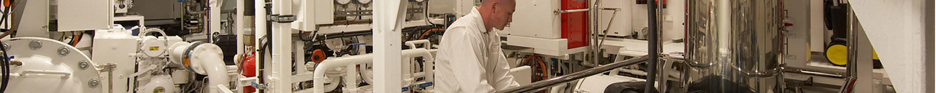 A superyacht engineer inspecting machinery in the engine room