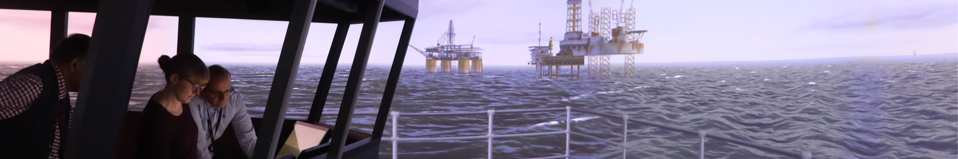 People using the DP simulator with images of oil rigs in the background