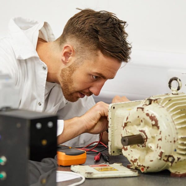 Electro-technical cadet repairing some machinery