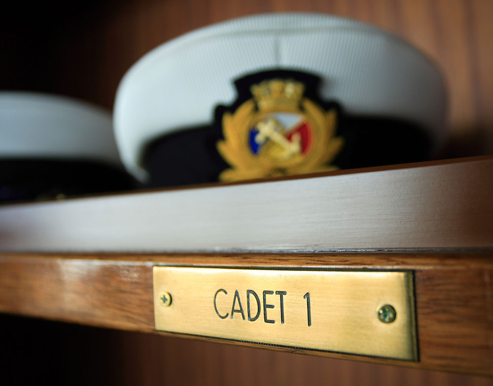 A Carnival cadet cap on a shelf with the label 'Cadet 1'