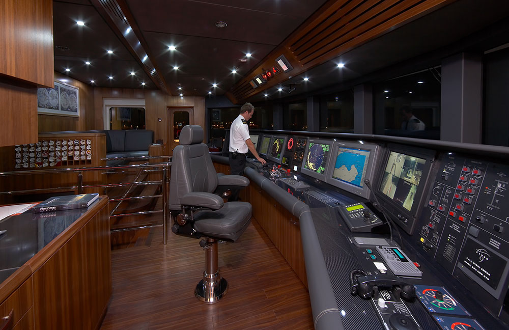 Deck officer on the bridge of a superyacht at night.