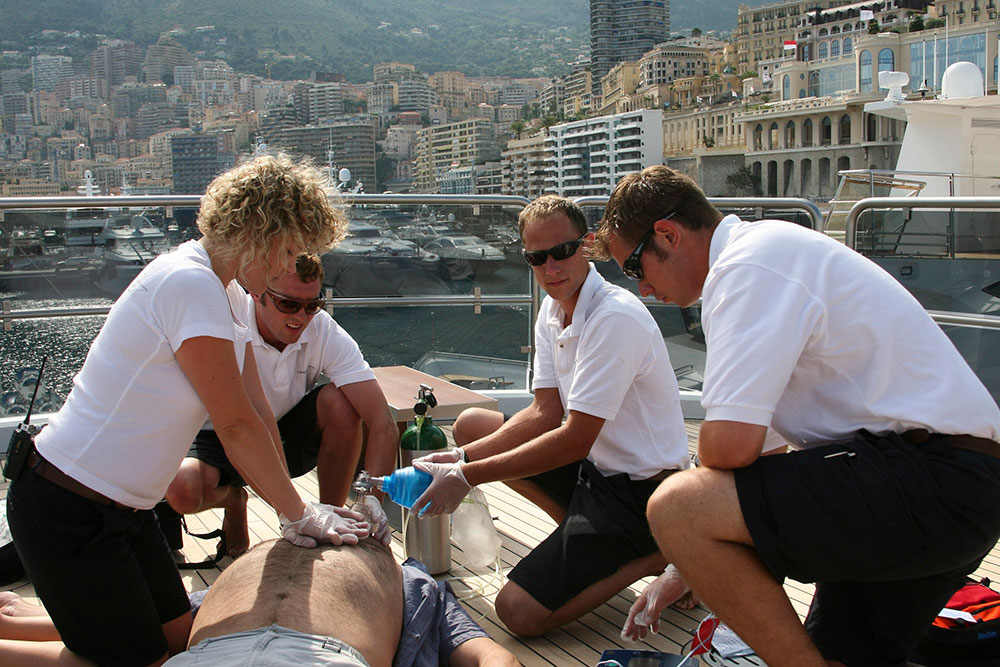 Superyacht crew giving medical assistance to a casualty on deck